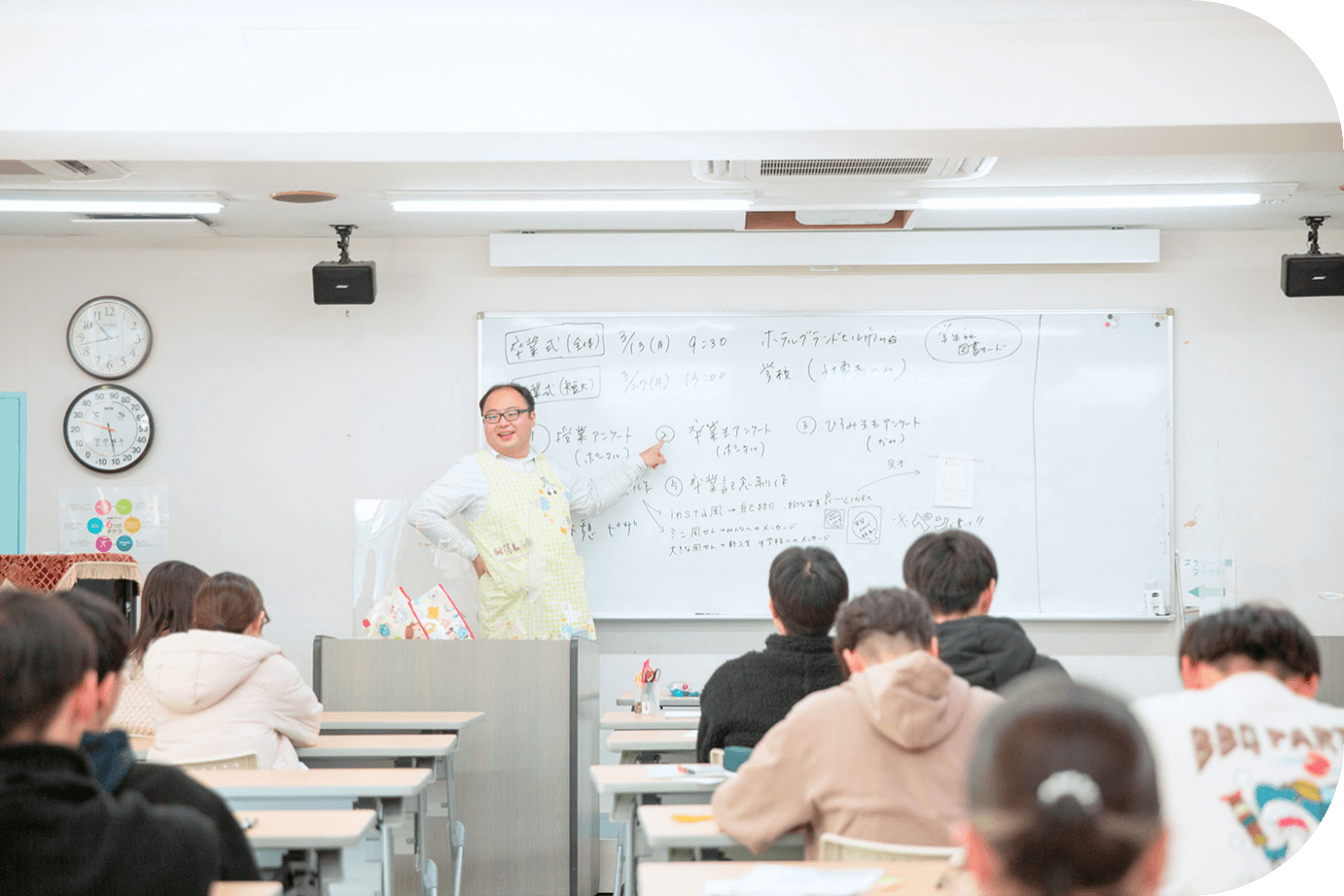 教壇で話す先生と生徒たち